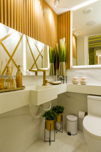 A vertical shot of a modern bathroom with white walls and large mirrors under the light