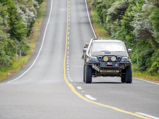 Toyota pickup truck front view, driving on straight hilly road toward camera. Auckland, New Zealand - November 30 2021