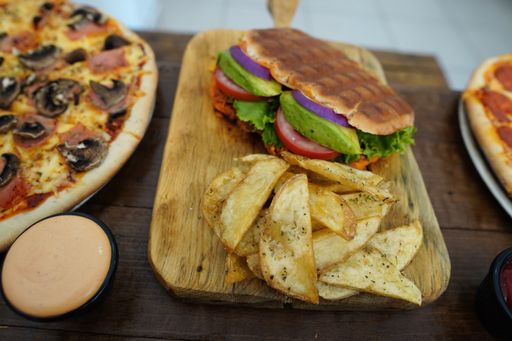 A closeup shot of a sandwich with chips on a wooden surface