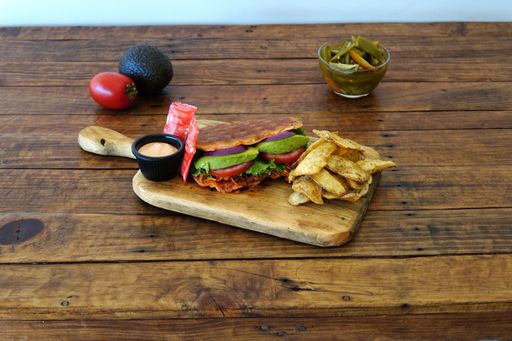 A closeup shot of a sandwich with chips on a wooden surface