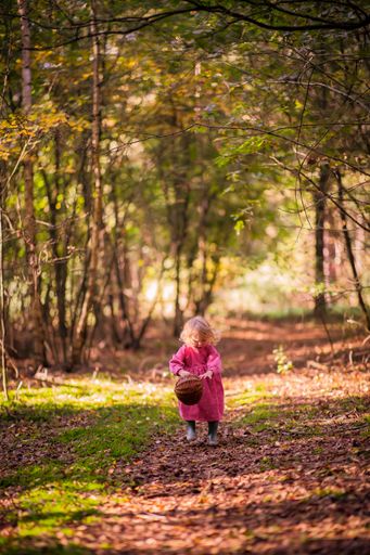A vertical shot of the cute little girl playing in the park.