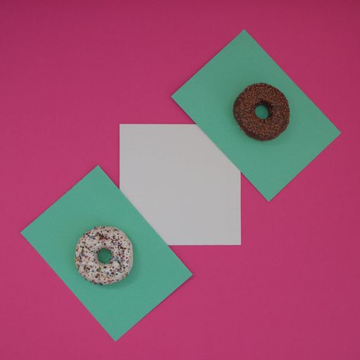A top view of two donuts on a light green surface, with white copy space, all on a pink background