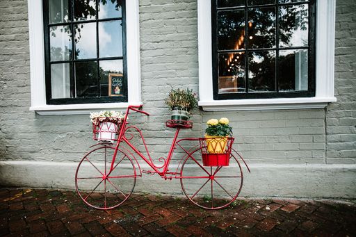 A beautiful shot of a red bike full of a bunch of flowers during the day