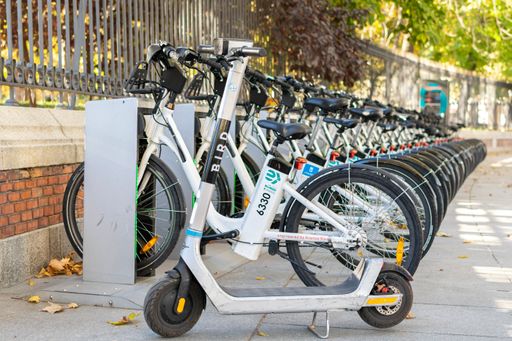 A bike share rental parking in Madrid with a scooter