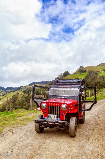 A vertical shot of a red jeep used for tours in the mountains of Salento, Colombia