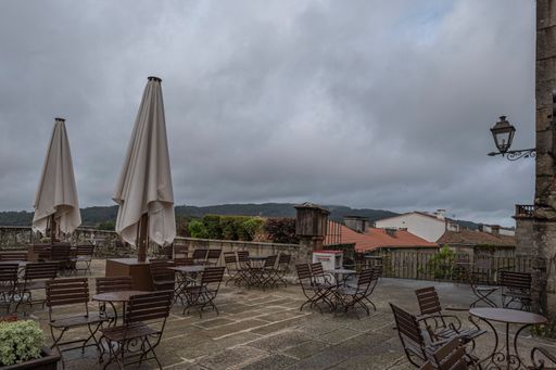 A perspective shot of wooden benches in the background of mountains in Santiago de Compostela, Spain.