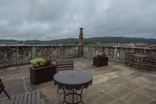 A perspective shot of wooden benches in the background of mountai in Santiago de Compostela, Spain.