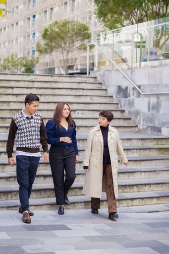 A scenic shot of Hispanic co-workers leaving the office talking about business together