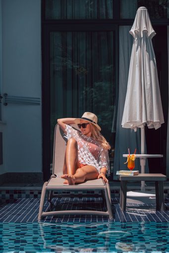 A vertical shot of a white Caucasian girl posing for a picture near the pool