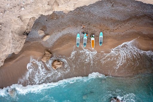 A bird's eye view of white Caucasian people with their colorful boats on a shore in Turkey