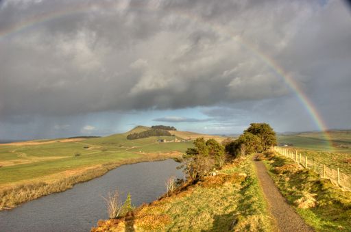 A closeup shot of the Hadrian's Wall path with a rainbow in Northumberland