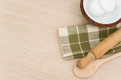 natural wood kitchen utensils and a table napkin on a wooden background with copy space