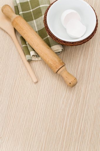 natural wood kitchen utensils and a table napkin on a wooden background with copy space