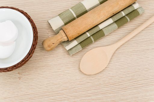 natural wood kitchen utensils and a table napkin on a wooden background with copy space