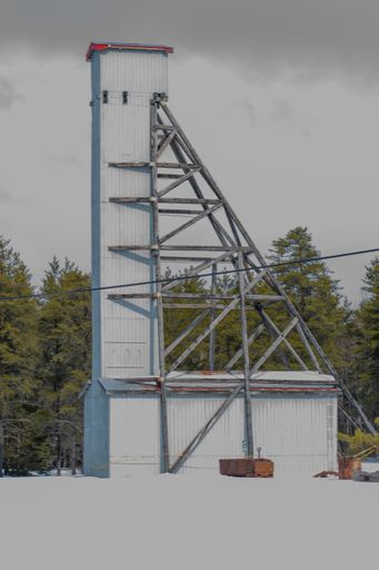 A vertical shot of a mining headframe at the junction near Cobalt Ontario under a cloudy sky