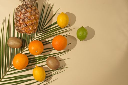 A top view of ananas and fruits on a beige background