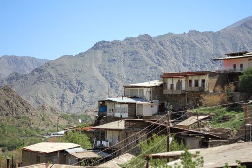 The traditional old village with trees and wire lines on the background of the mountains