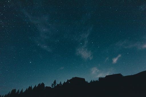 A beautiful view of the Milky way and stars in the evening sky over a landscape in Austria