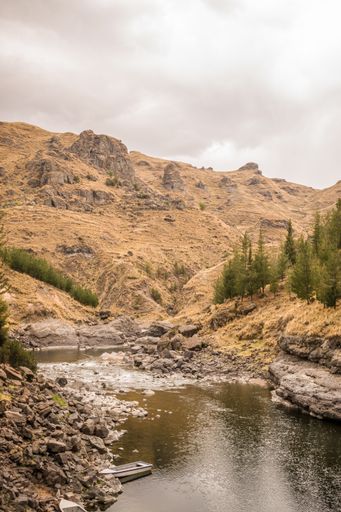 A scenic shot of the Apurimac river valley in Cusco, Peru, on a cloudy day surrounded by mountains