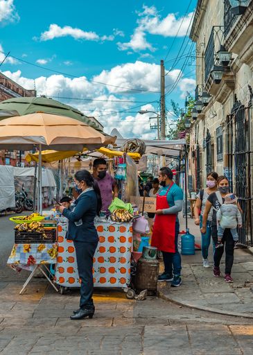 A vertical shot of street vendors and people walking in downtown Oaxaca, Mexico