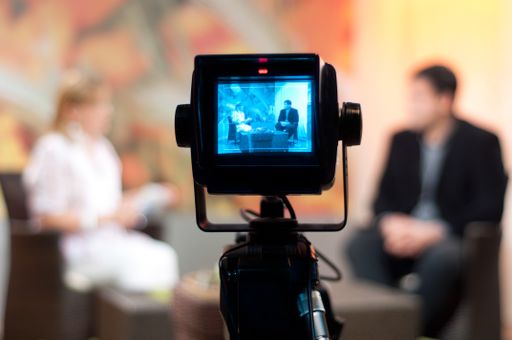 A shallow focus of a Video camera viewfinder, recording show in a TV studio during a talk show