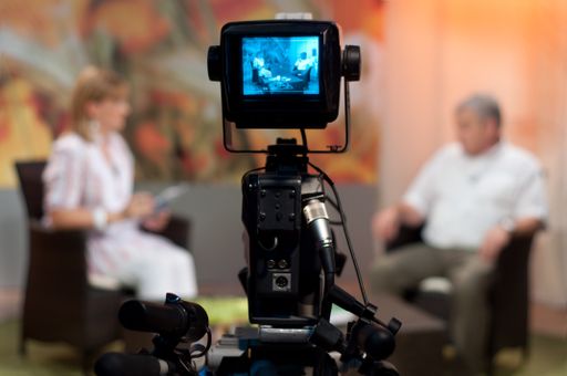 A shallow focus of a Video camera viewfinder, recording show in a TV studio during a talk show