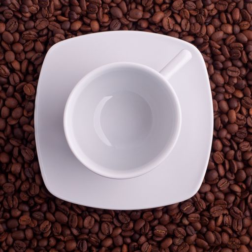 A top view of empty coffee beans with white cup