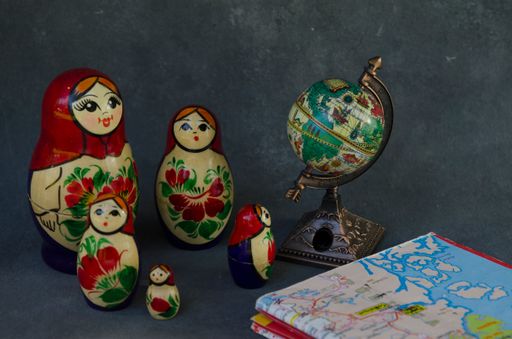 The five traditional Russian matryoshka dolls gathered next to a map planning a trip