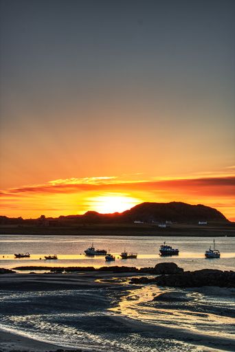 A vertical shot of Scotland isle of mull coast and lake at sunset dusk