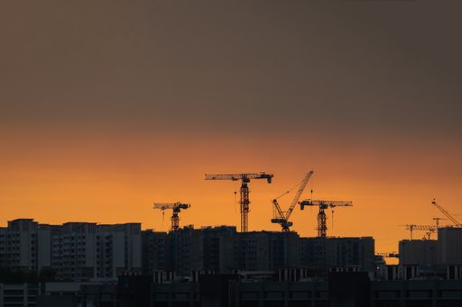 The silhouette of construction cranes against the sunset sky in Singapore