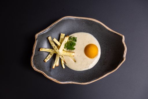 A top view shot of a gourmet dish on a black plate