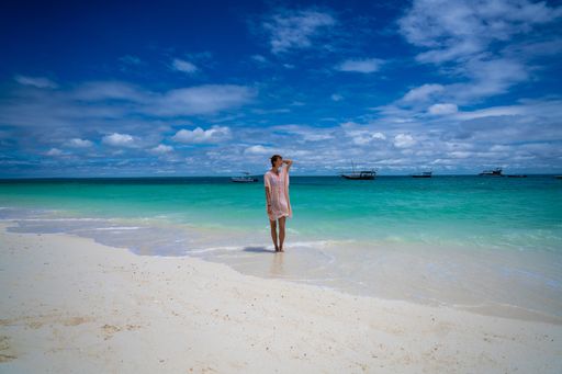 A Caucasian (White) woman standing on the beach. Zanzibar, Tanzania