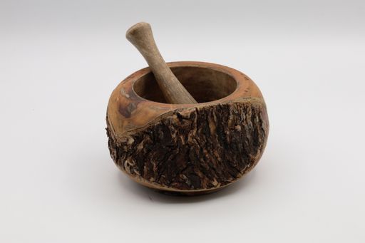 A closeup shot of a mortar with pestle isolated on white background.