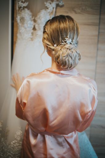 A vertical shot of the bride's holding her wedding gown