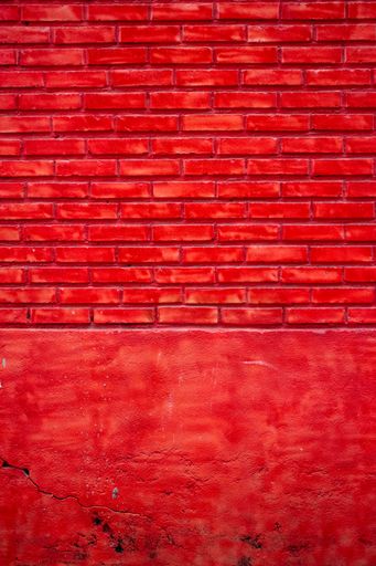 A vertical shot of a painted red brick wall