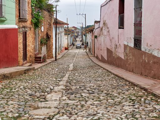 A wide shot of a cobblestone street near houses in Havana, Cuba