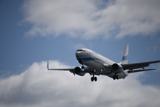A low angle shot of an airplane flying in the blue sky among the clouds