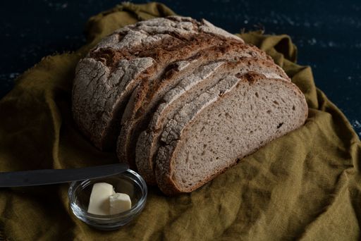 A Homemade freshly baked country bread made from wheat and whole-grain flour sliced with butter