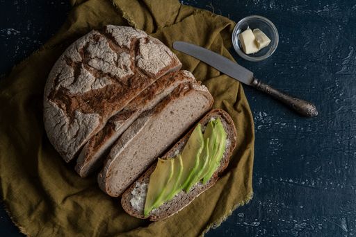 A top view of freshly baked sliced bread with butter and avocado
