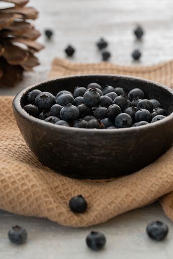 A vertical shot of ripe blueberries on a bowl with cloth on a table