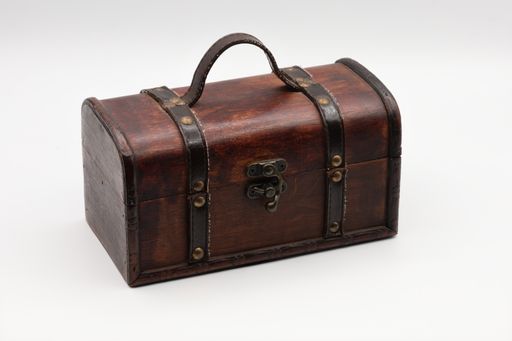 A photo of a closed wooden chest trunk on white background