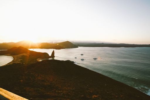 A beautiful shot of boats in the sea near the shore with a mountain in the distance under a beautiful sky