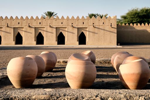 A close-up shot of pots in the courtyard of Al Jahili Fort in UAE under a blue sky on a sunny day