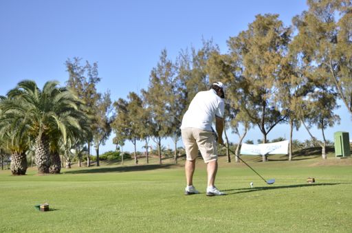 A photo of a man playing golf on a sunny day