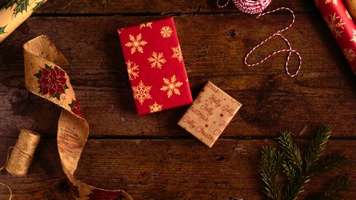 Natural Christmas eco gift wrapping flat lay  red and natural craft paper wrap with jute twine and ribbon for Boxing Day wooden table