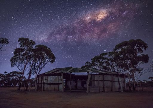 A beautiful view of the Milky Way over a destroyed wooden building