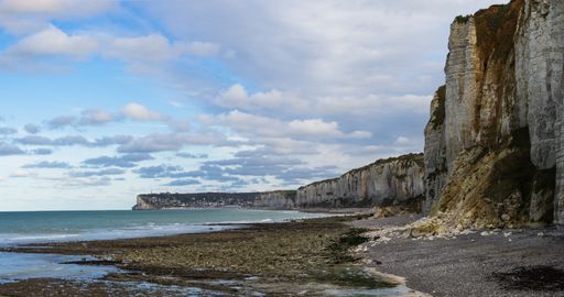 A mesmerizing view of rock formations on the coast of the sea against a cloudy sky