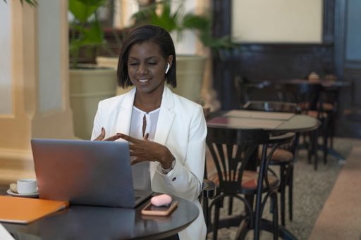 An African American female sitting in a cafe and working in front of a laptop