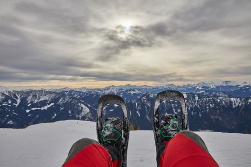 A beautiful shot of snowshoes with a view of a landscape covered in snow in winter