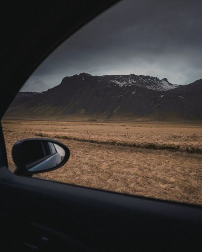 A brownfield shot from inside a vehicle under a gray cloudy and gloomy sky